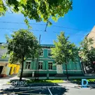 Офис с паркетным полом и изразцовой печью в историческом деревянном здании.
